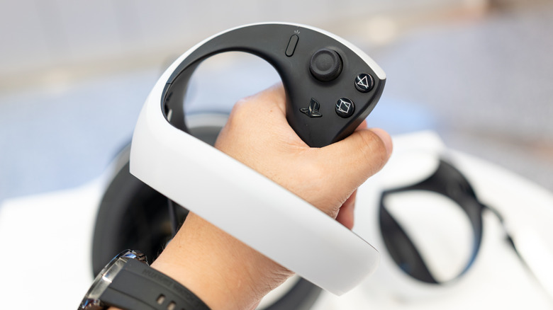 Hand holding a PS VR2 controller.