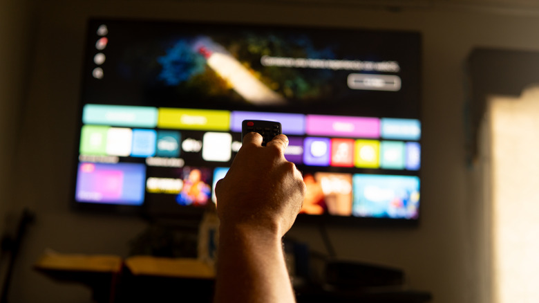 Hand holding remote pointing at a smart TV