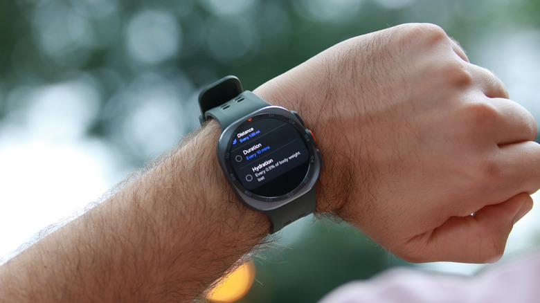 The Galaxy Watch Ultra 2 on a person's wrist, with its screen showing the hydration reminder setup.