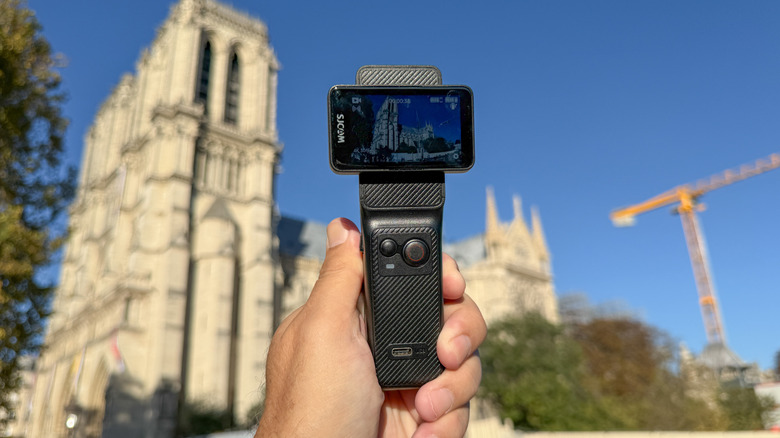 SJCam's C400 gimbal camera is shown against the Notre Dame cathedral in Paris.