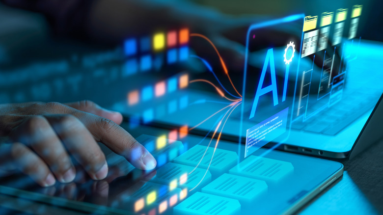 A graphic of hands pressing keys on a laptop with holographic icons of AI, apps and folders floating above.