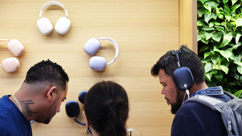 Customers wearing the AirPods Max in an Apple Store.
