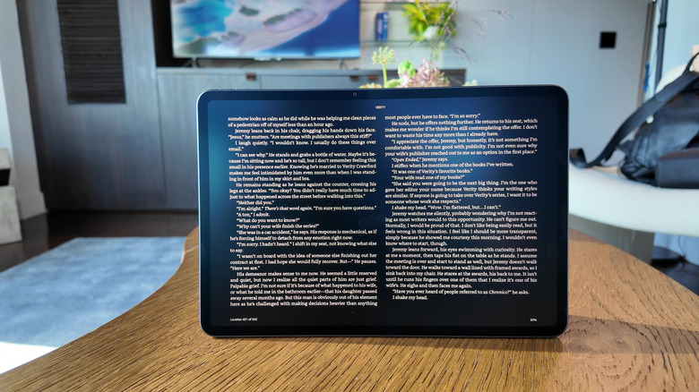 An Amazon Alexa Tablet 12 Pro sitting on a wooden table with Kindle Mode on.