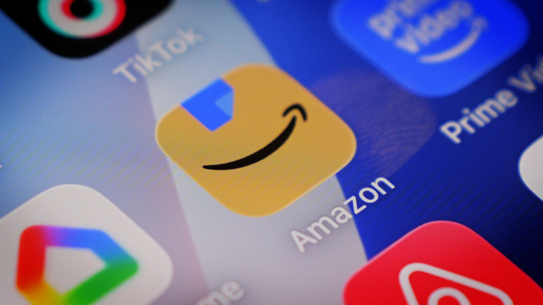 The Amazon app logo is shown on an iPhone 16 Pro display