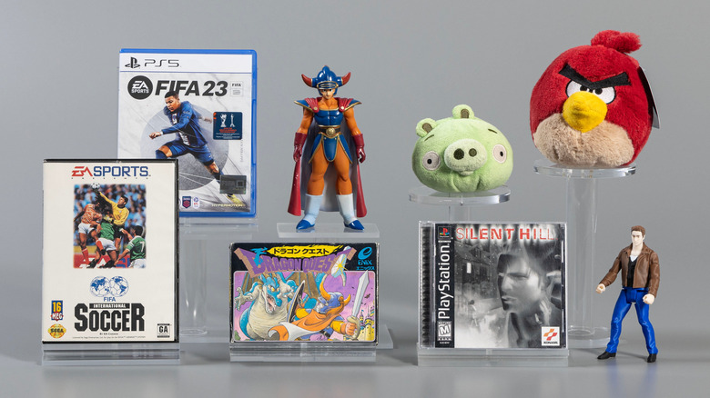 Game boxes and toys representing the World Video Game Hall of Fame class of 2026 inductees: FIFA International Soccer, Dragon Quest, Angry Birds and Silent Hill