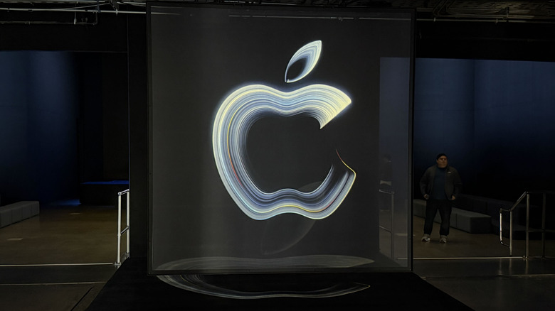 An Apple logo on a black wall at the Apple event.
