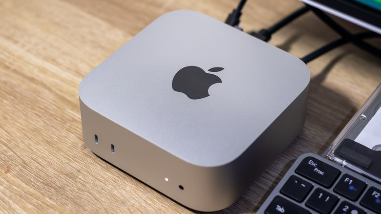 A Mac Mini on a wooden desk.
