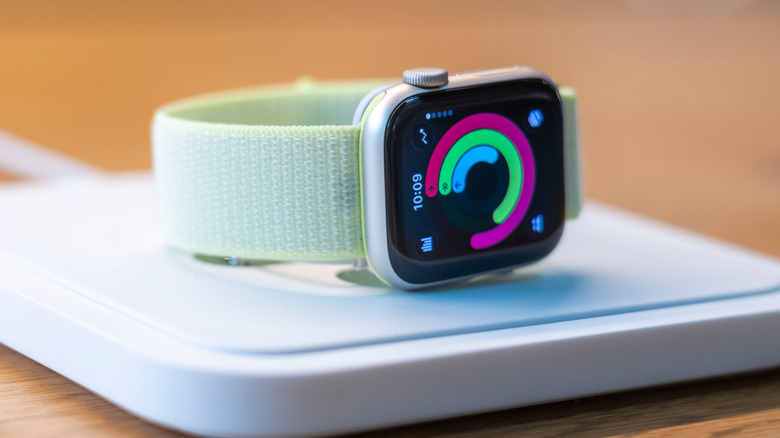 An Apple Watch Series 11 lying flat on a platform in a store showing rings.