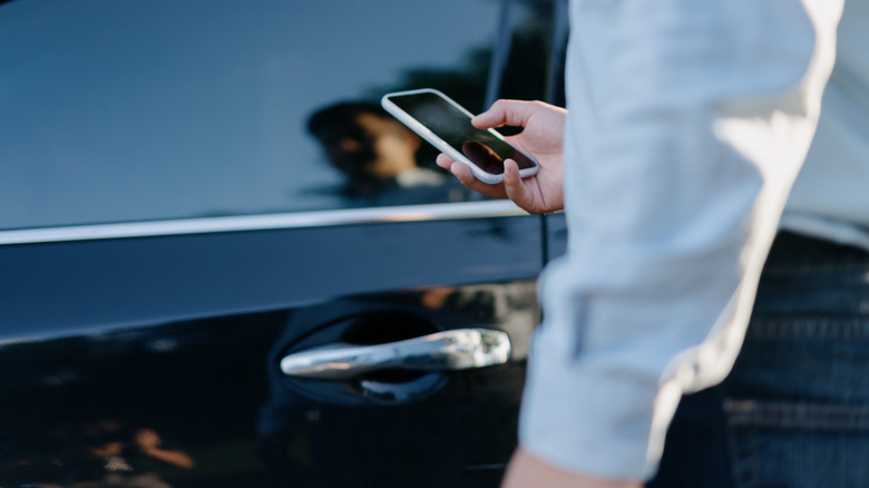 Man using his phone near his car