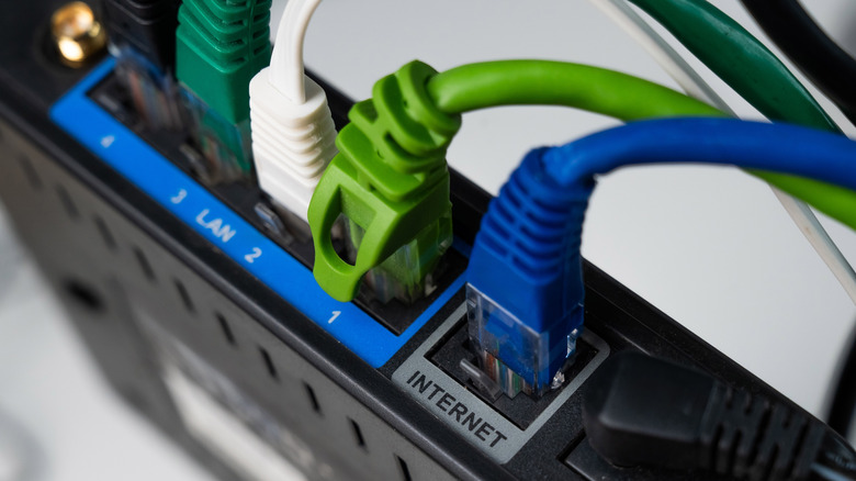 Close-up of several Ethernet cables connected to a router, including the Internet and LAN ports.