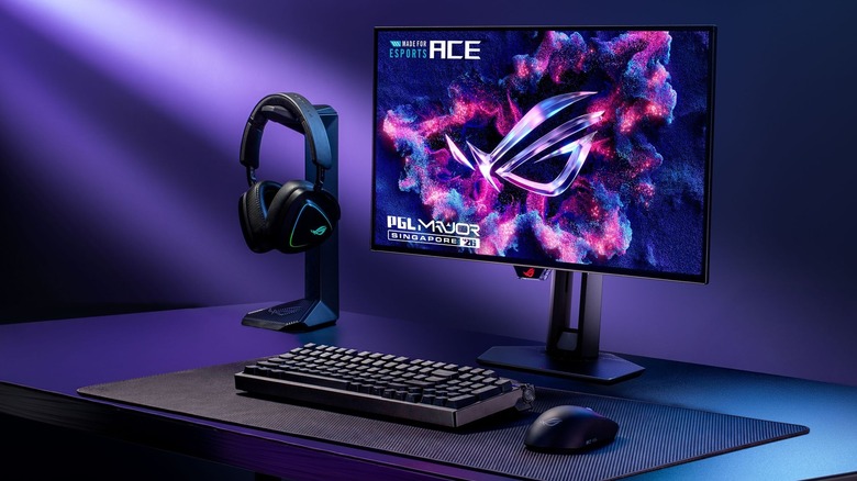 The new flagship ASUS ROG Ace esports gaming monitor next to a keyboard, headphones and a mouse.