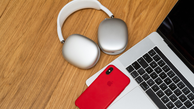 AirPods Max next to an iPhone and MacBook.