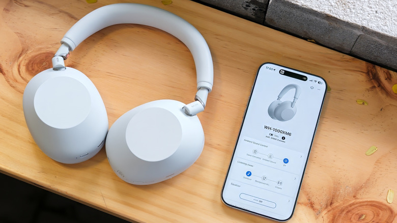 White Sony WH-1000XM6 headphones and the Sony Connect app on an iPhone.