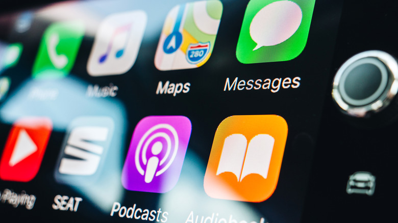 Apple CarPlay dashboard showing apps including Phone, Music, Maps, Messages, Podcasts and Audiobooks.