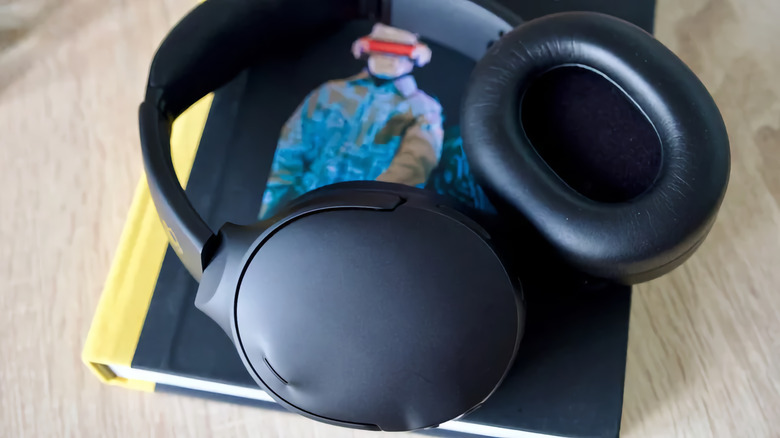 The Skullcandy Crusher 1080 headphones laying on a book.