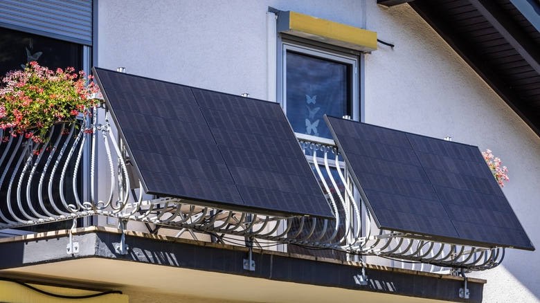 Two solar panels are shown on an apartment balcony