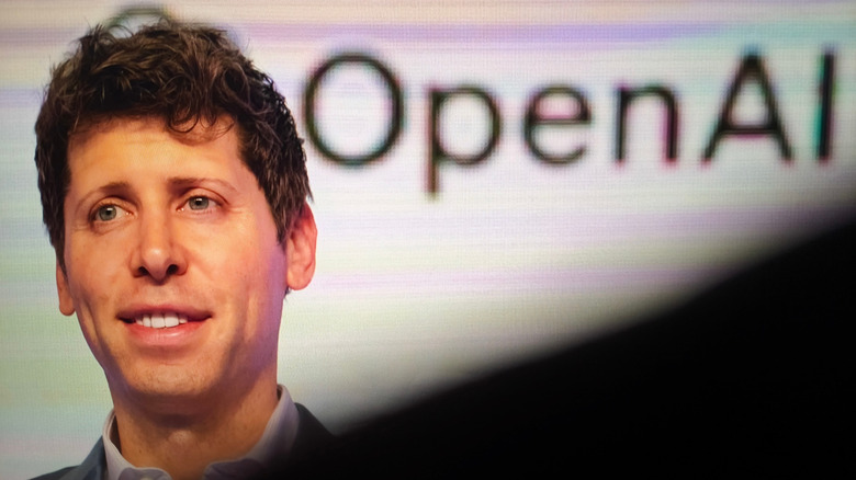 A man in the foreground with the OpenAI logo in the background.