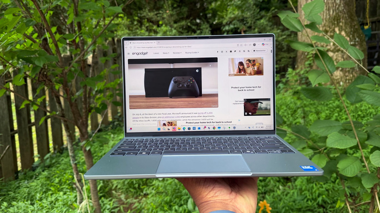 Holding up the XPS 13 in a backyard.