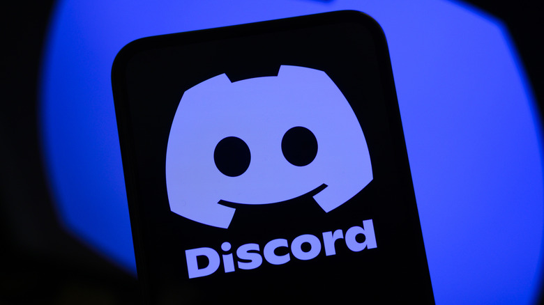 Smartphone showing the Discord logo in front of a black and blue background