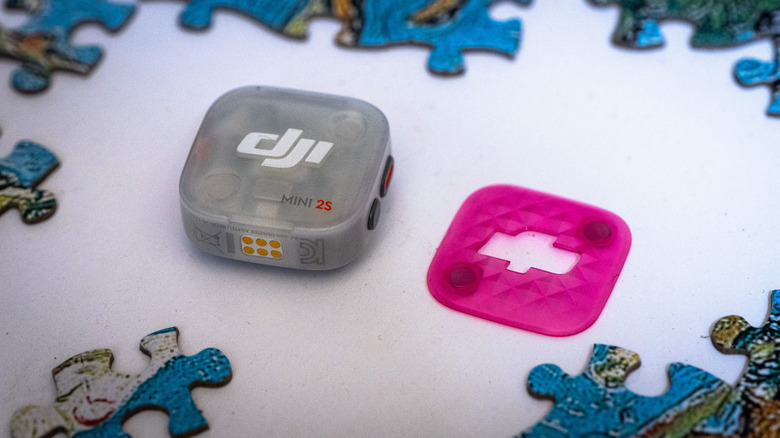 DJI's Mic Mini 2S camera charging kit with two transmitters, a receiver, wind muffs and colored cover plates