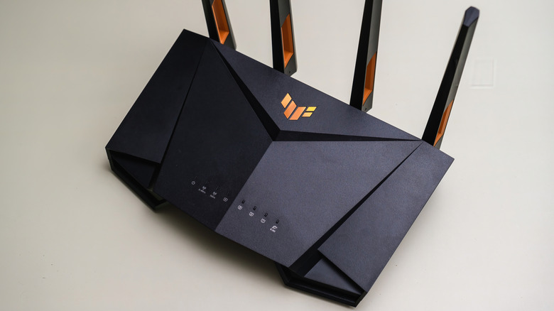 A close-up of an ASUS TUF gaming router with four antennae.