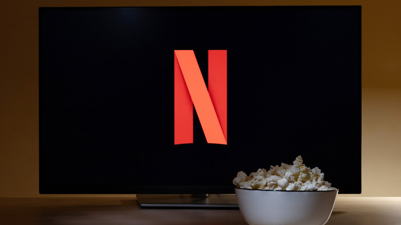 A large monitor showing the Netflix logo with a bowl of popcorn in front of it.