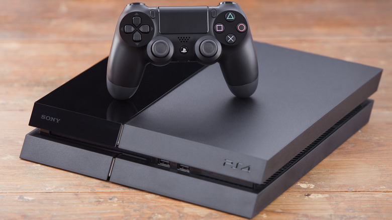 Dualshock 4 ontop Playstation 4 on a wooden surface.