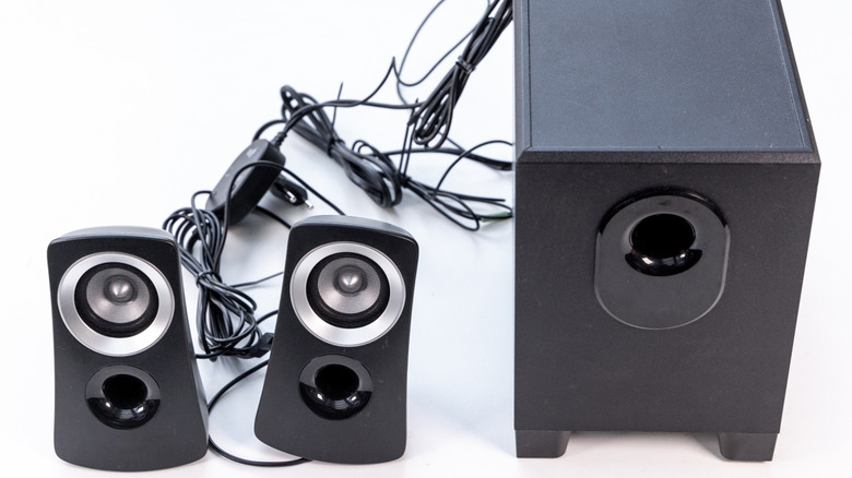 Old PC speakers with cords behind them.