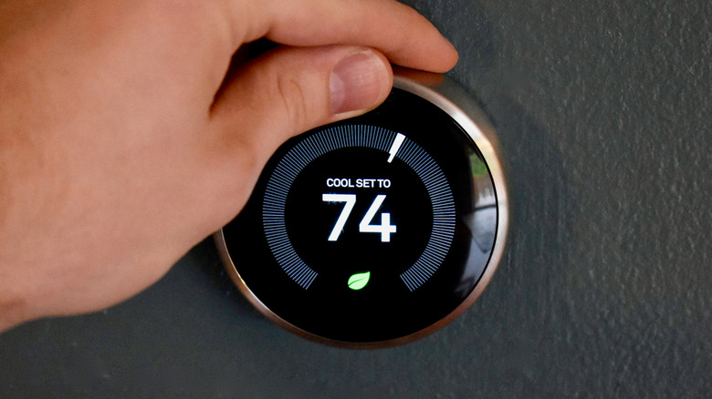 Spinning the temperature ring on an older Nest Thermostat.