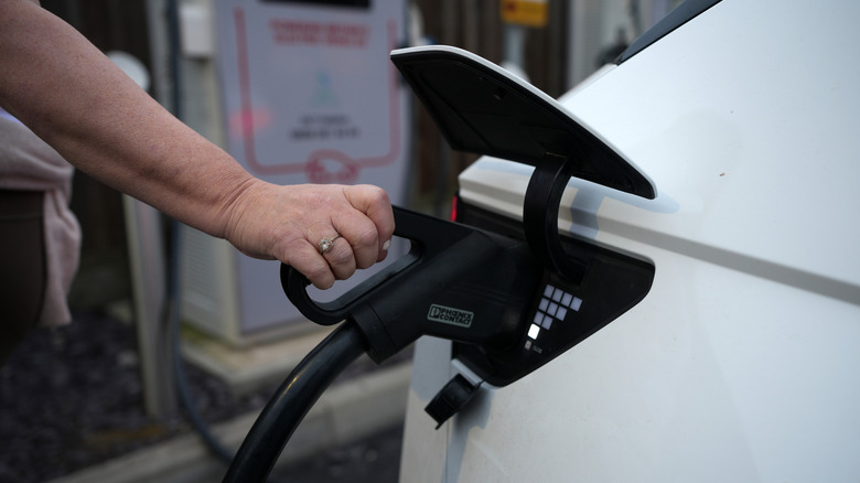 Person charging electric vehicle