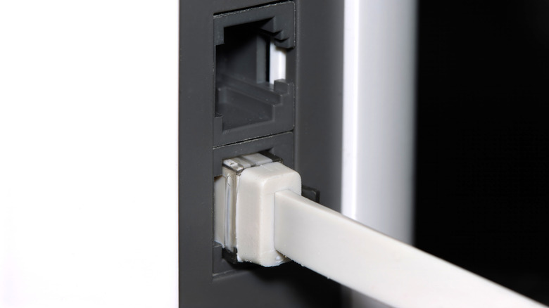 A flat Ethernet cable plugged into a mesh Wi-Fi router.