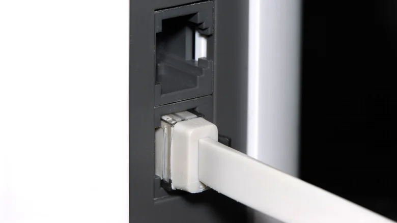 A flat Ethernet cable plugged into a mesh Wi-Fi router.