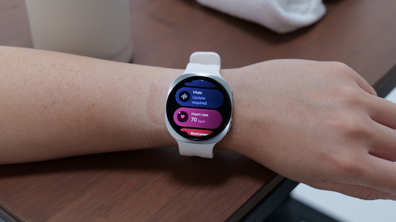 A smartwatch with heart rate and vitals features displayed.