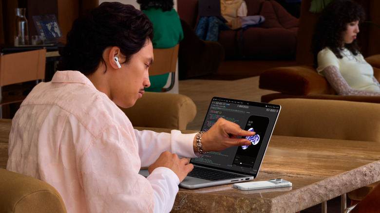 A person using a laptop's touchscreen.