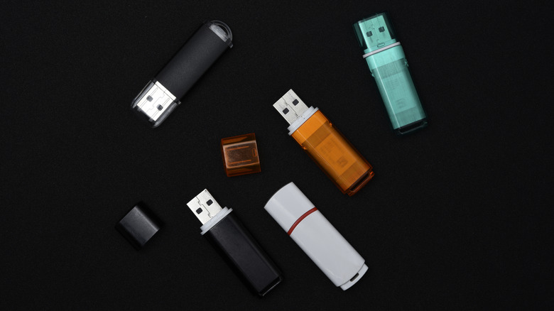 Various USB flash drives on a black background.