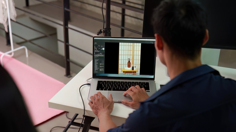 A photographer editing a product shoot on his laptop.