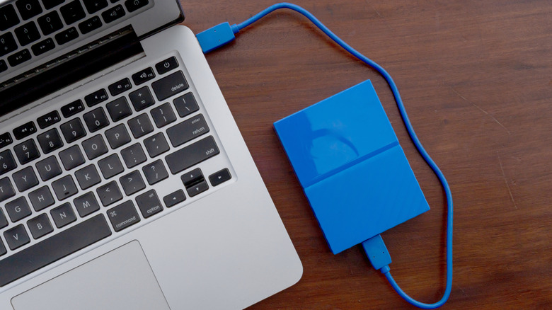 A blue external drive attached to a MacBook.
