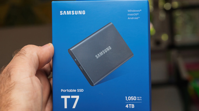 Uma m&atilde;o segurando uma caixa SSD port&aacute;til Samsung.