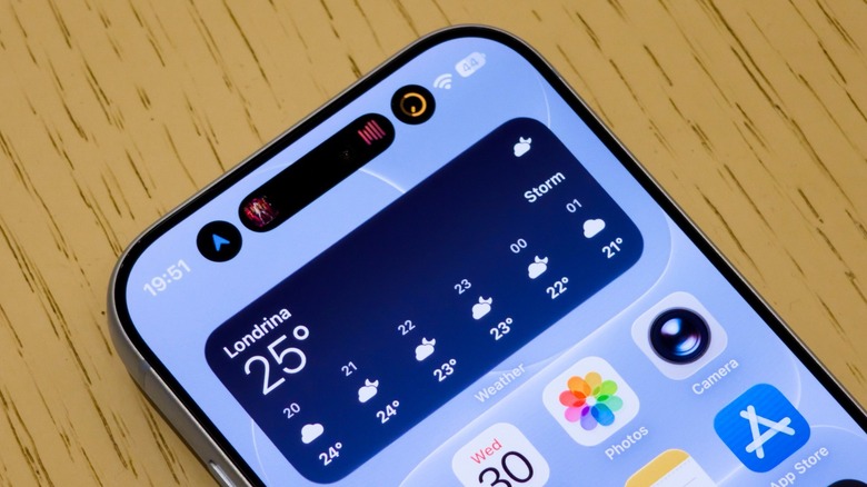Dynamic Island on the iPhone 18 Pro showing three different Live Activities.