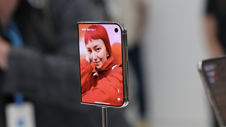 A silver iPhone Duo folded with its outer display turned on.