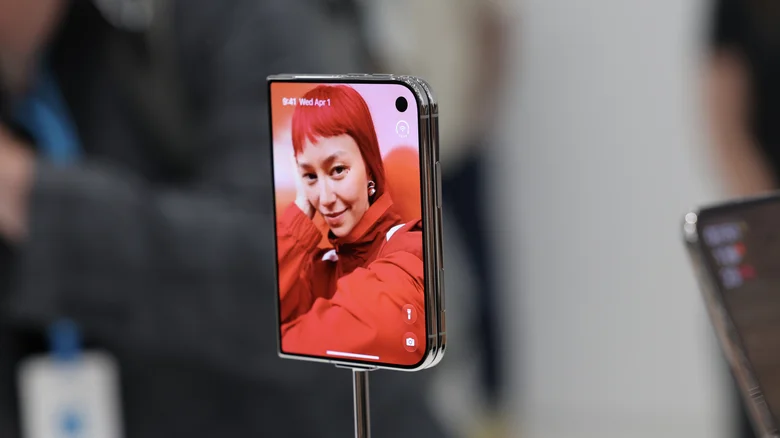 A silver iPhone Duo folded with its outer display turned on.