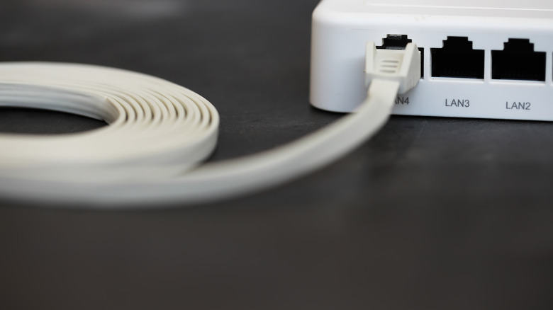A flat ethernet cable plugged into a port on a router.