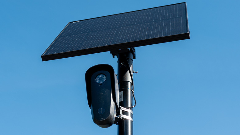 Flock license plate reader and camera with solar panel against a blue sky