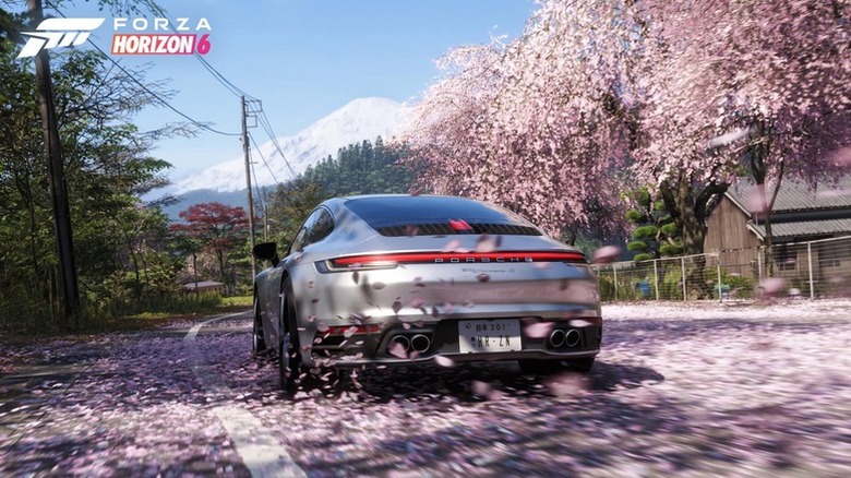 Screen capture from the game Forza Horizon 6 showing a Porsche Carrera driving over cherry blossoms with Mount Fuji in the background