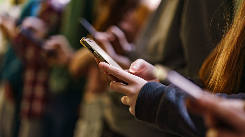 A row of children using smartphones.