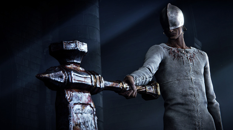 A person wearing a helmet that covers their eyes points a large hammer-like weapon