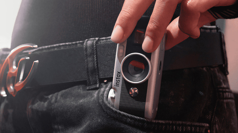 Someone pulling an Instax Pal 2 out of their pocket.