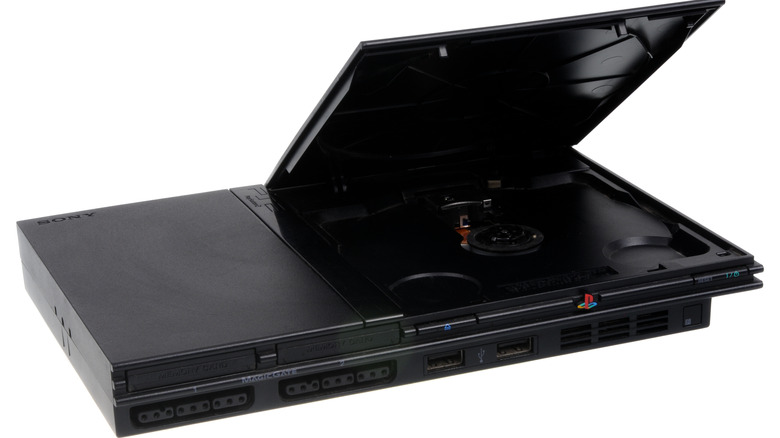 A PS2 SlimLine console with the disc cover open.