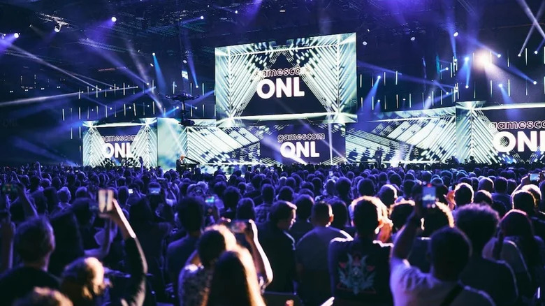 A large audience in front of a big stage with the words "Gamescom ONL" on multiple screens.
