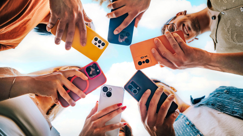 A variety of smartphones being held.